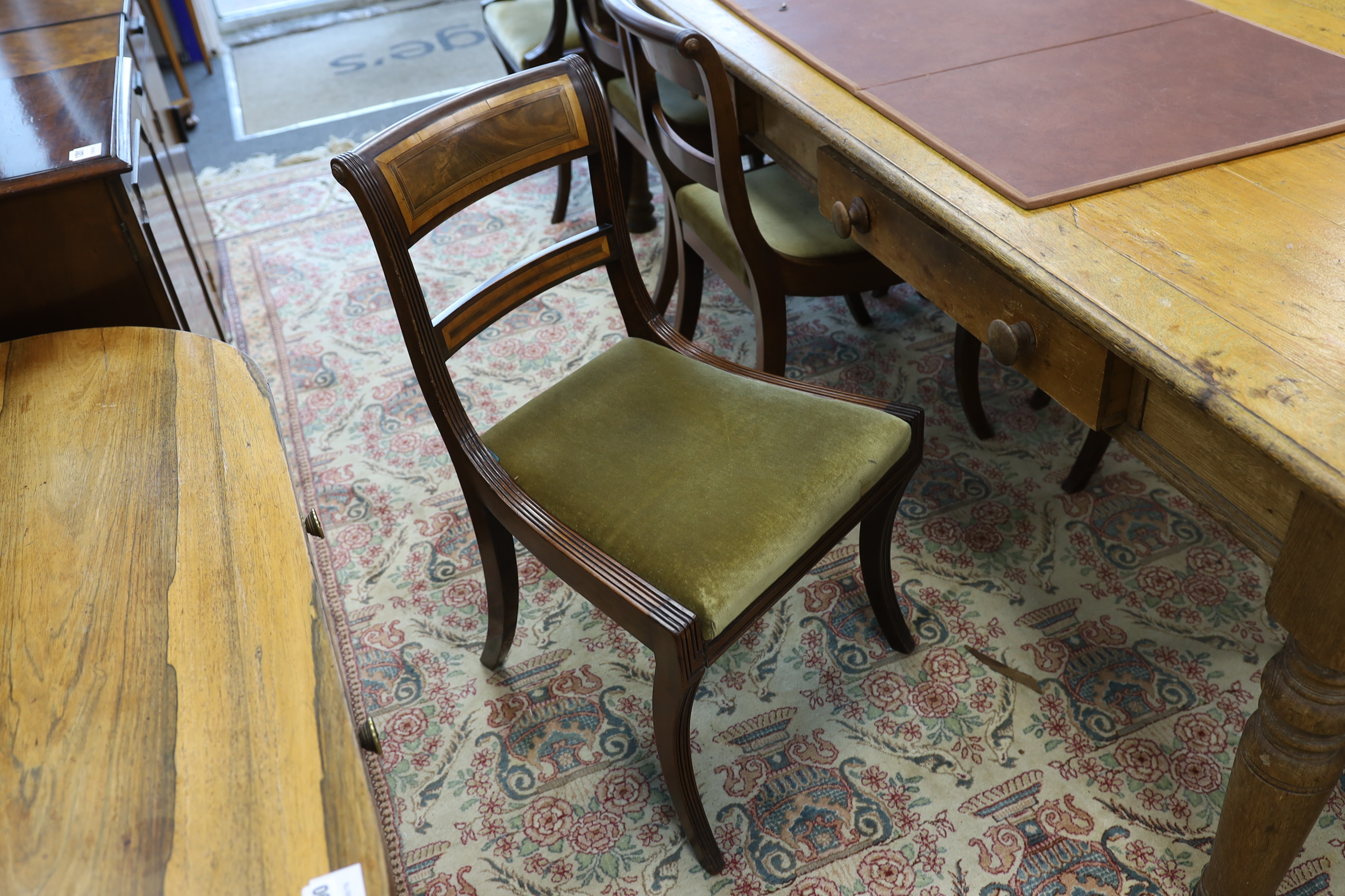 A set of eight Regency mahogany and satinwood banded sabre leg dining chairs, two with arms